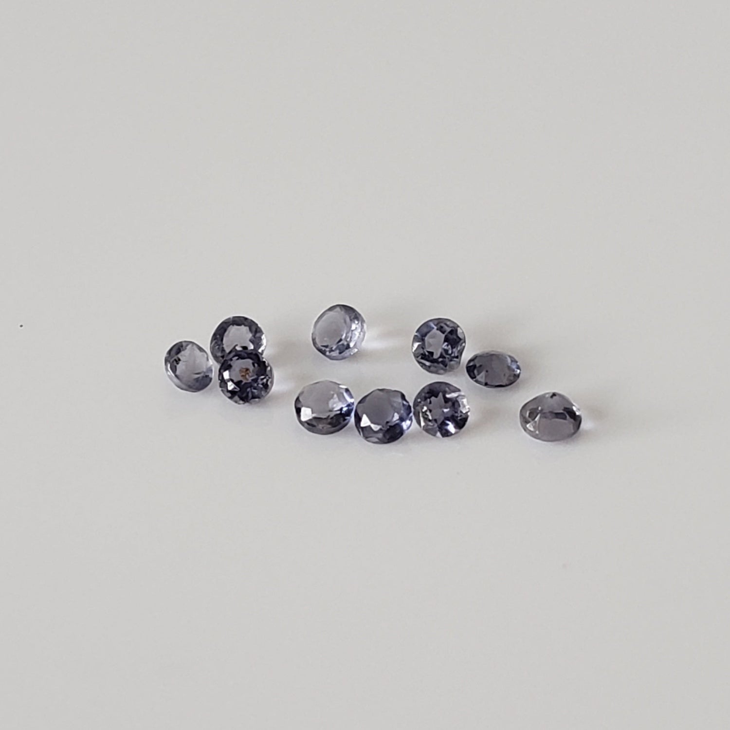Iolite | Lot de 10 pierres précieuses. | Coupe ronde | Bleu violet | 0,13 tcw